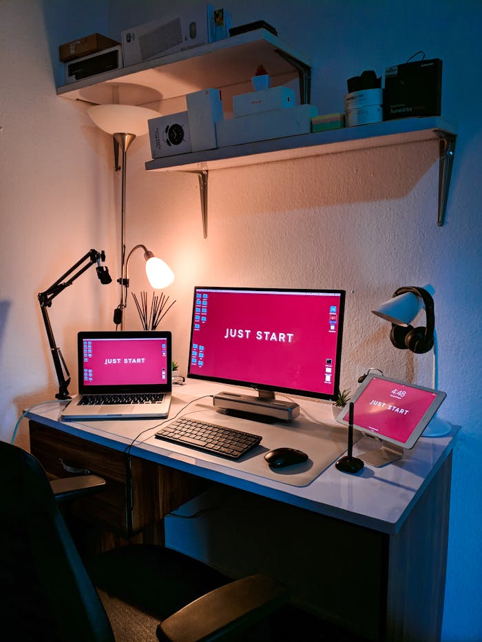 our-services-04 A stylish home office setup featuring a laptop, monitor, and tech accessories on a desk with cozy lighting.